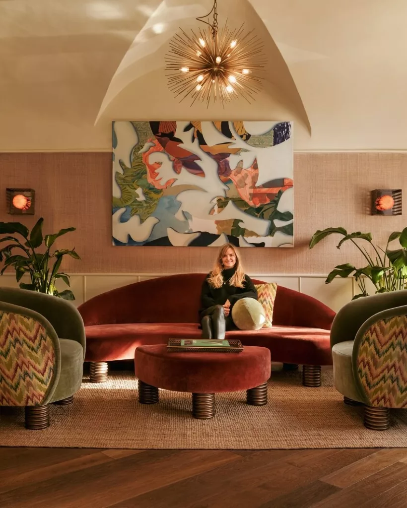 Theresa Obermoser sitting on a stylish couch inside the award-winning Am Hof 8.