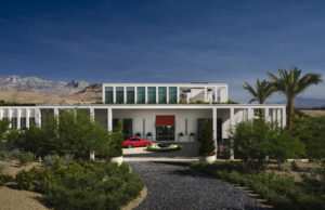 Exterior view of Tombolo residence surrounded by palms with mountains in the distance